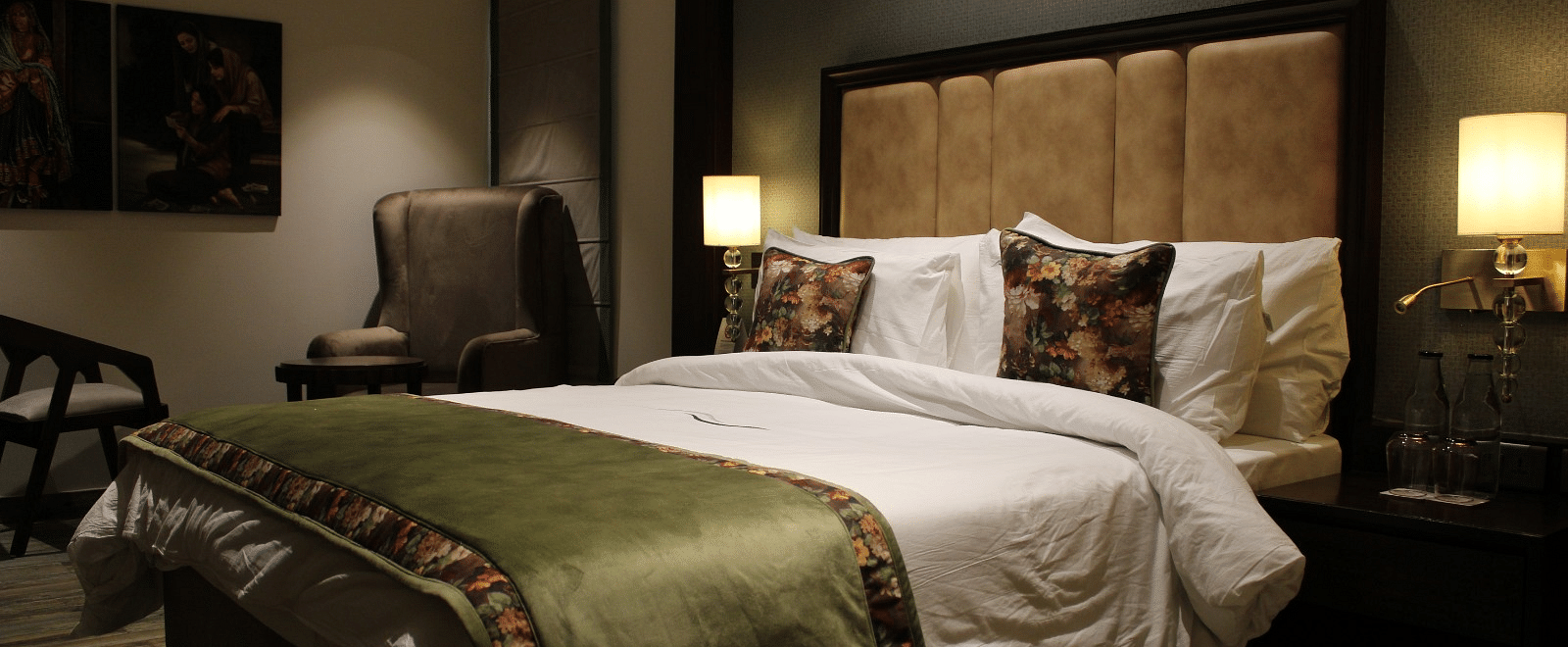 Side view of the bedroom with multiple pillows arranged on the bed and a huge chair next to it at BluSalzz Residence, Amritsar